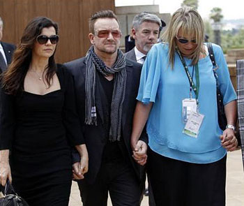 The U2 singer-activist Bono, was pictured holding the hands of his wife Ali and also of Zelda le Grange, the former assistant to Mr Mandela, as they walked past the casket of the former South African president.